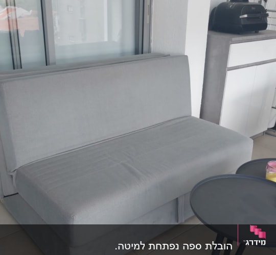 ספה אפורה ליד שולחן עגול קטן
